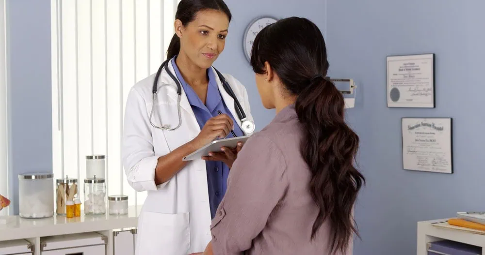A primary care provider speaking with a patient during an office visit