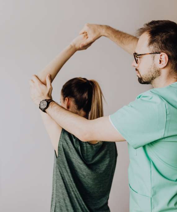Therapist guiding a patient's shoulder movement